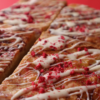 A picture of the delicious blondies on a red background.