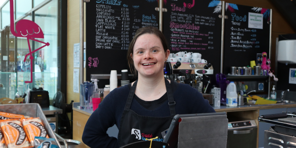 A woman standing at a counter smiling