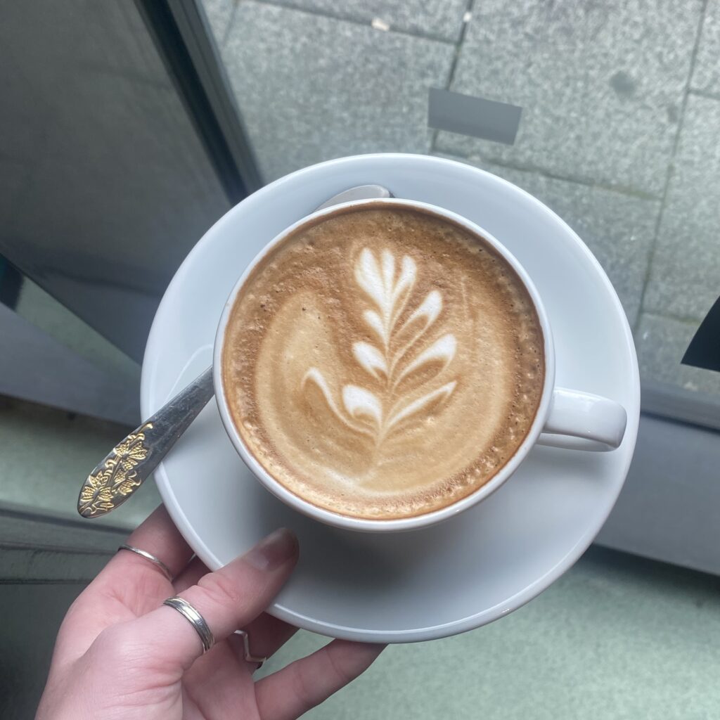 A Picture of a latte with a pretty design on it