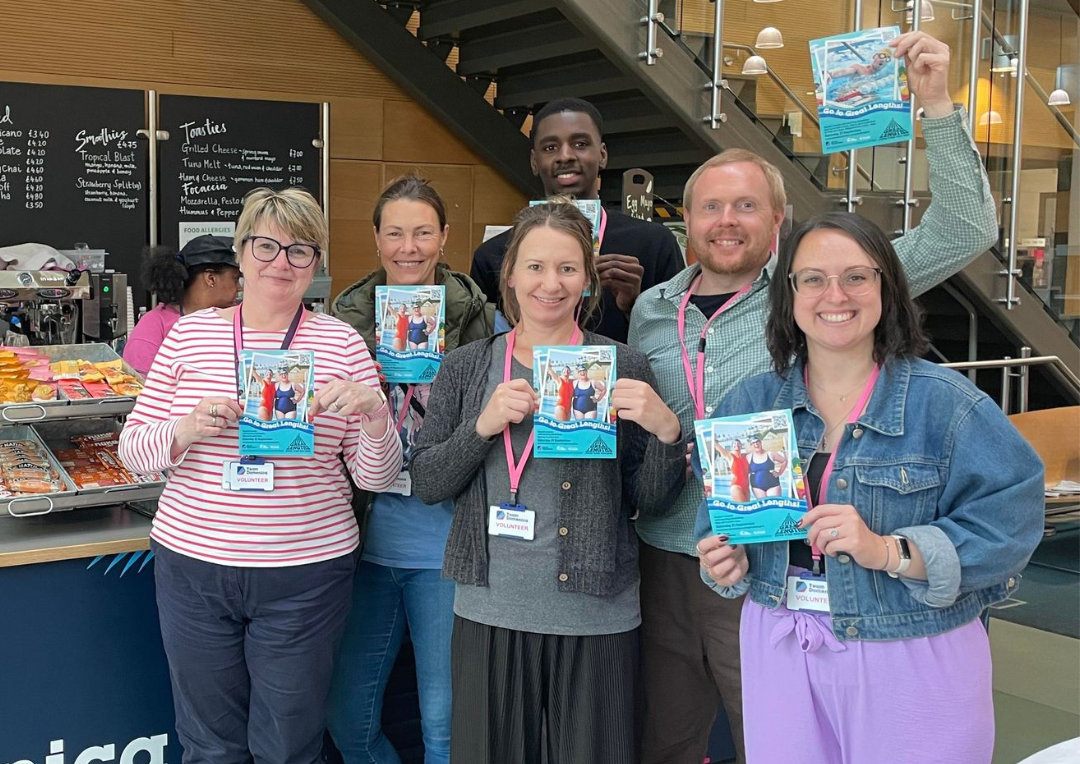 A picture depicting a group of 6 people holding Great Lengths flyers at Cafe Domenica. They are all employees at OneFamily.