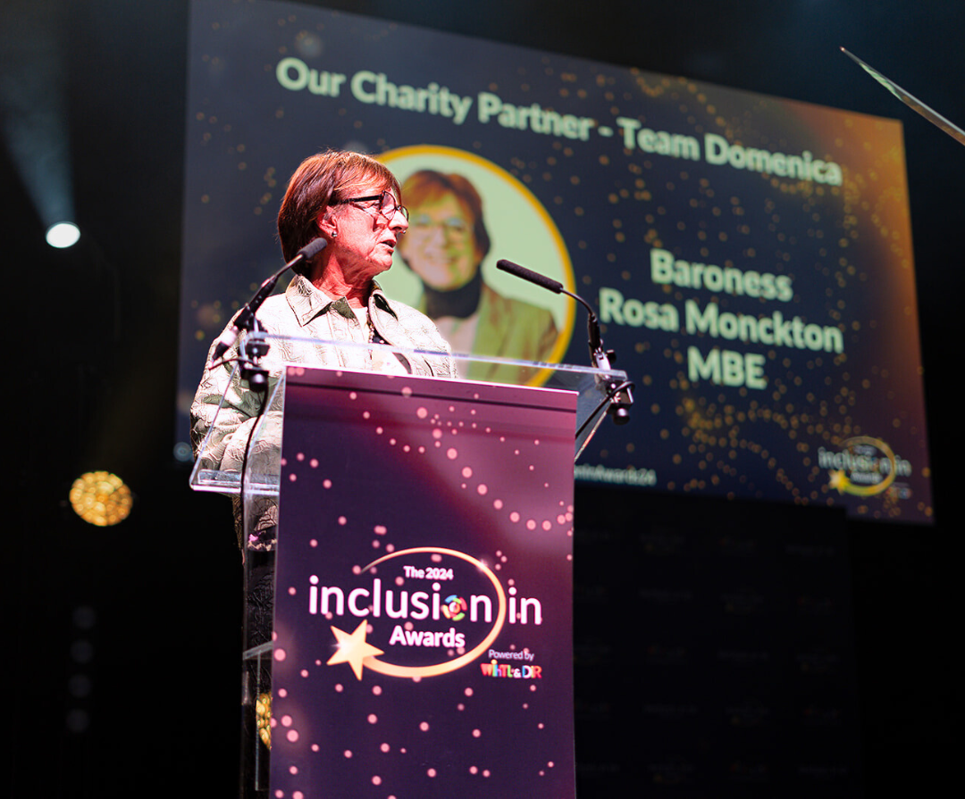 Baroness Rosa Monckton MBE stands behind a podium whilst speaking at WiHTL & DiR's Inclusion in Awards