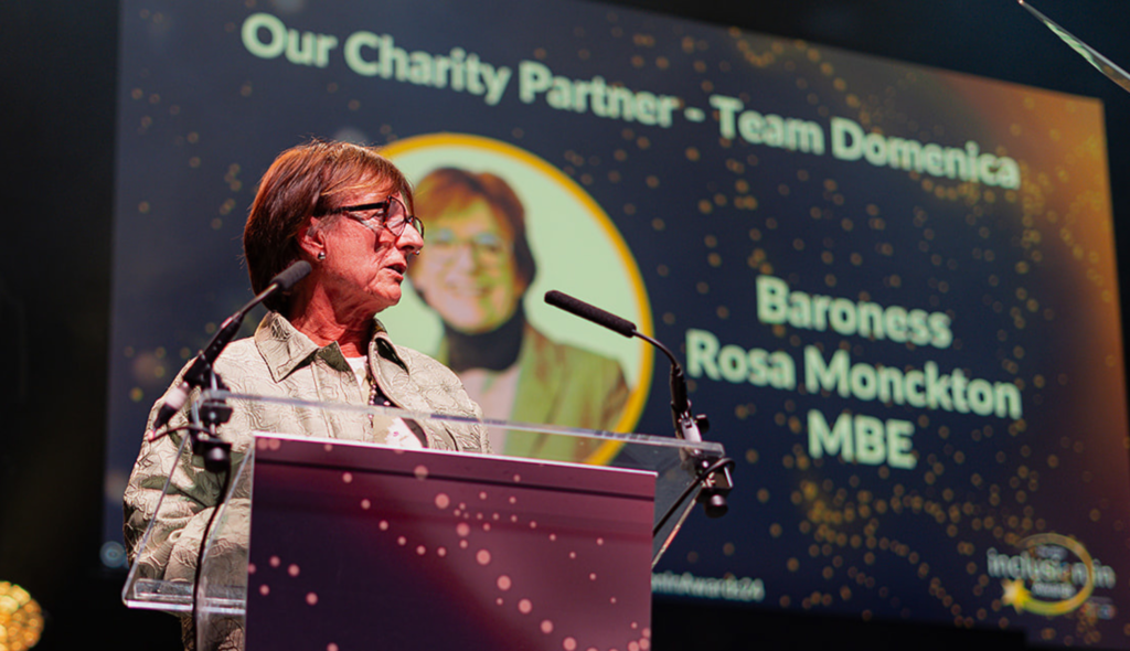 Baroness Rosa Monckton MBE stands behind a podium whilst speaking at WiHTL & DiR's Inclusion in Awards