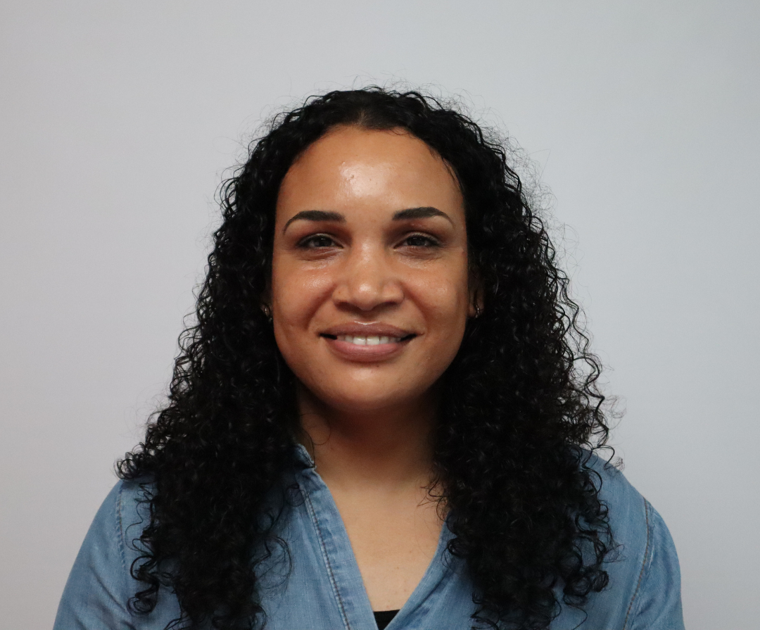A headshot of Ruth Thomas. She is black and has dark brown curly hair.