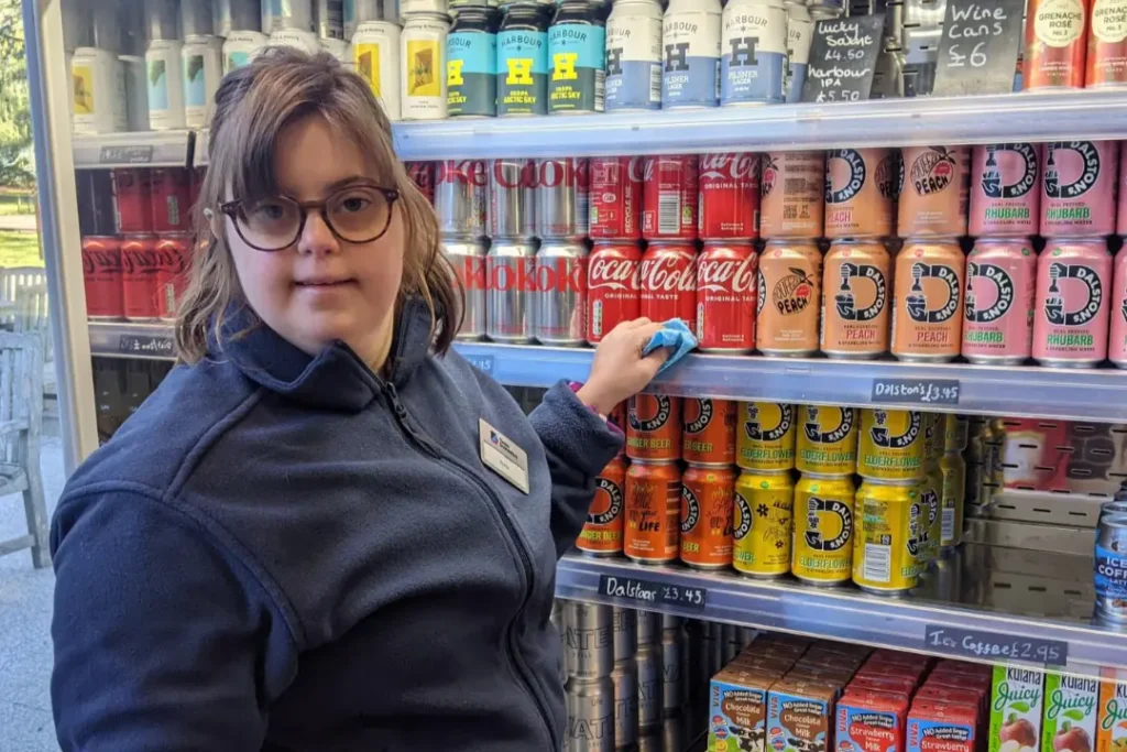 A Team Domenica candidate, Annie, restocking a fridge at her job at Wakehurst, Kew Gardens