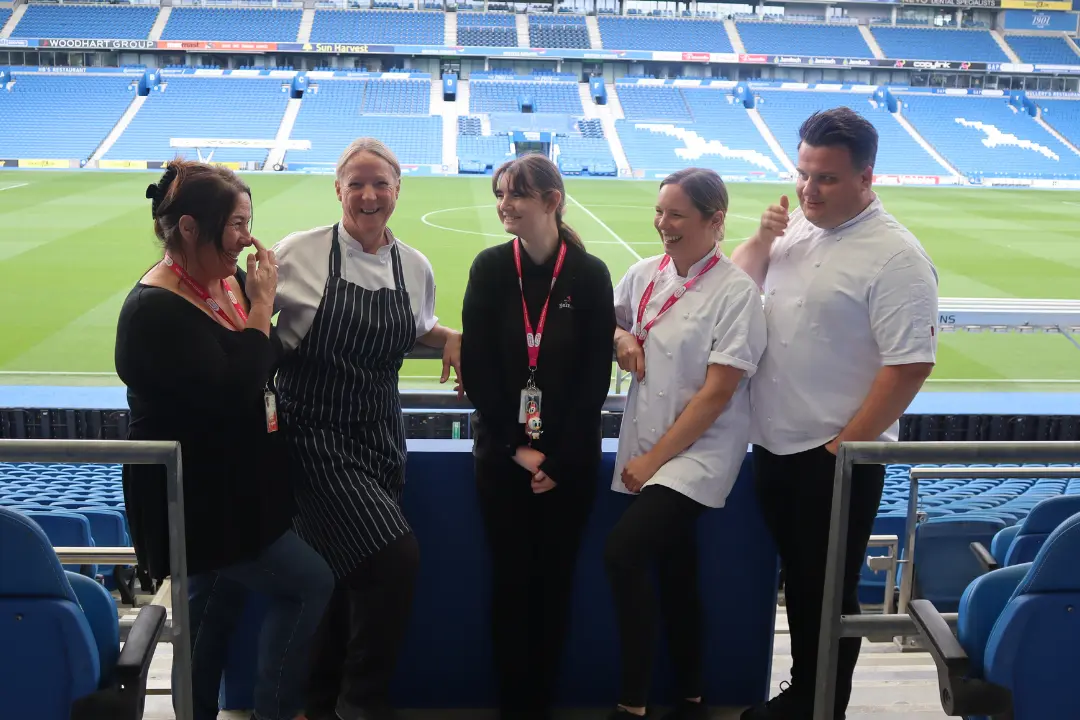 A Team Domenica candidate in paid work laughing with four of her colleagues