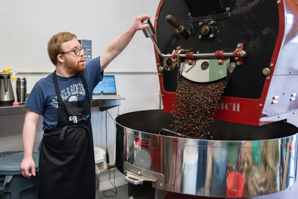 A Team Domenica candidate roasts coffee ready to be packaged and sold