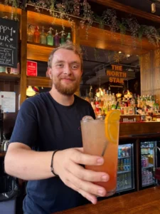 Bar manager Adam at The North Star serving unique Pride cocktail to customer
