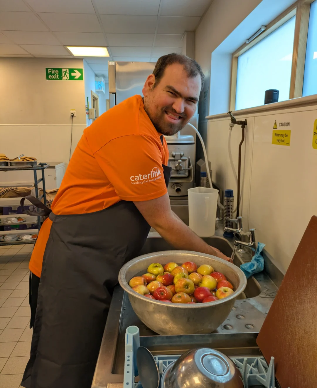 Team Domenica candidate washing up in a commercial kitchen.