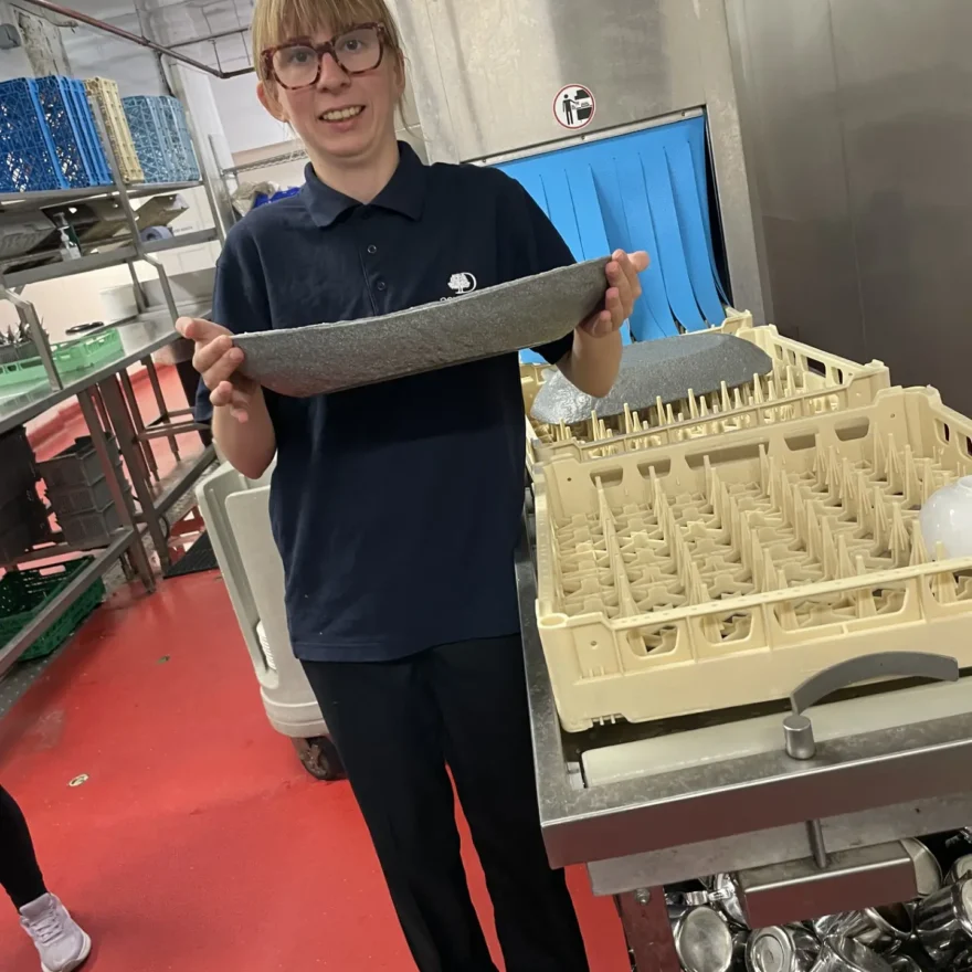 Team Domenica candidate holding a plate in commercial kitchen